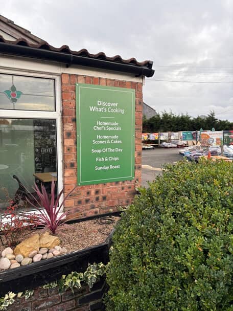 An image of a green exterior menu board.